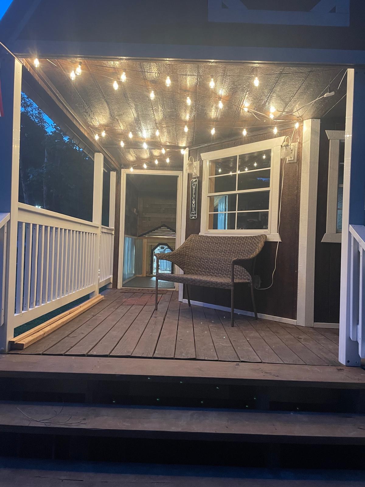 Front porch lit with string lights at dusk
